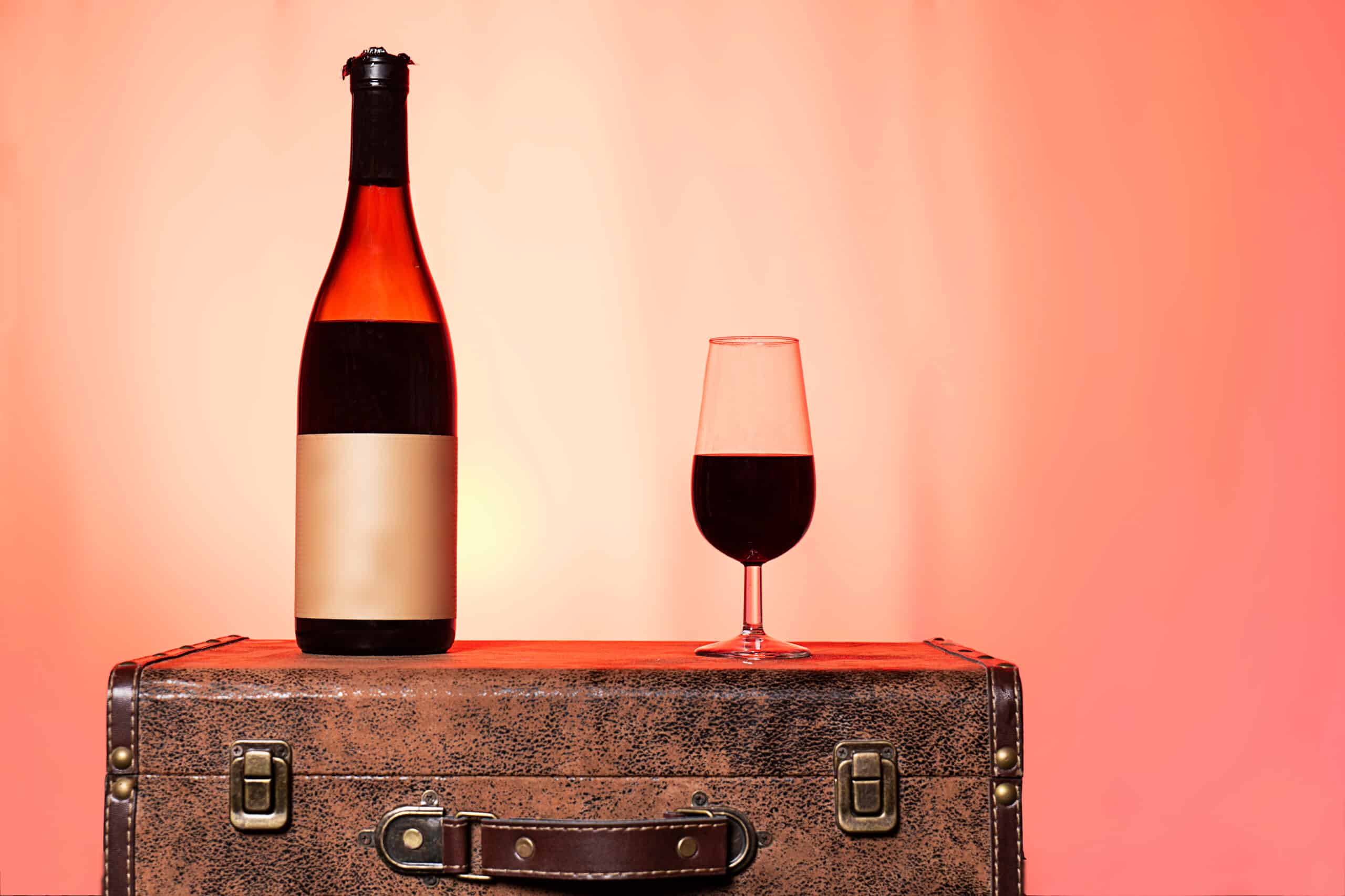 wine bottle and glass on a suitcase