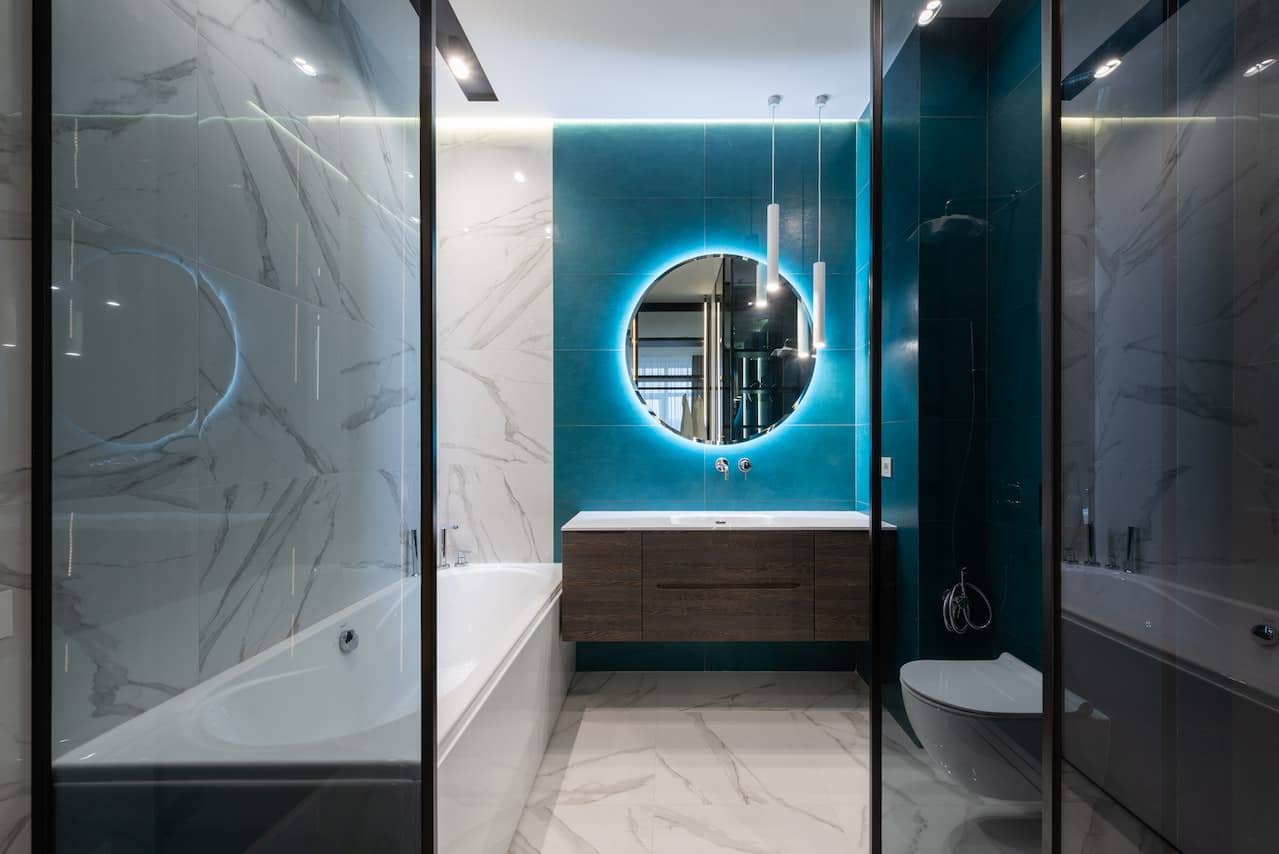 Modern hotel washroom with sink, toilet, and bathtub. Best place to put luggage is in the bathtub.